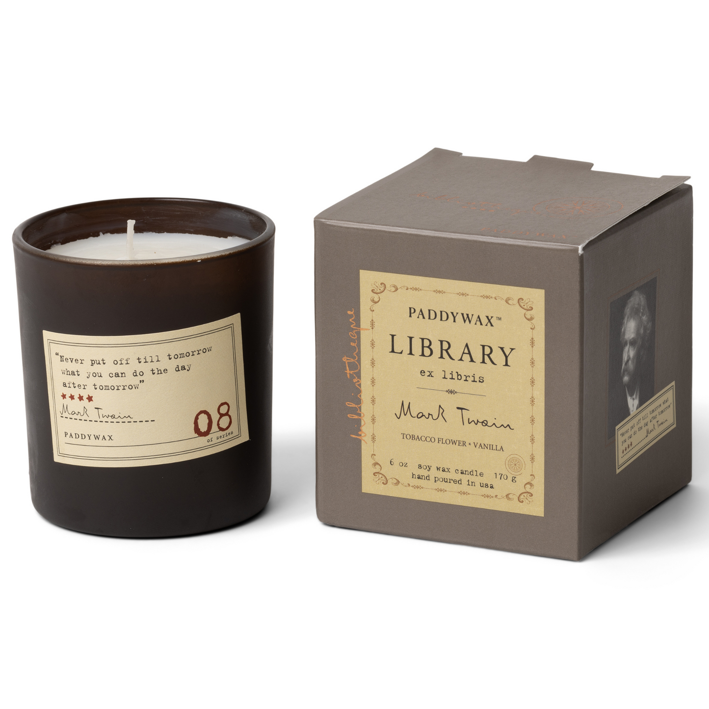 Black candle with cream label next to grey box with gold label.