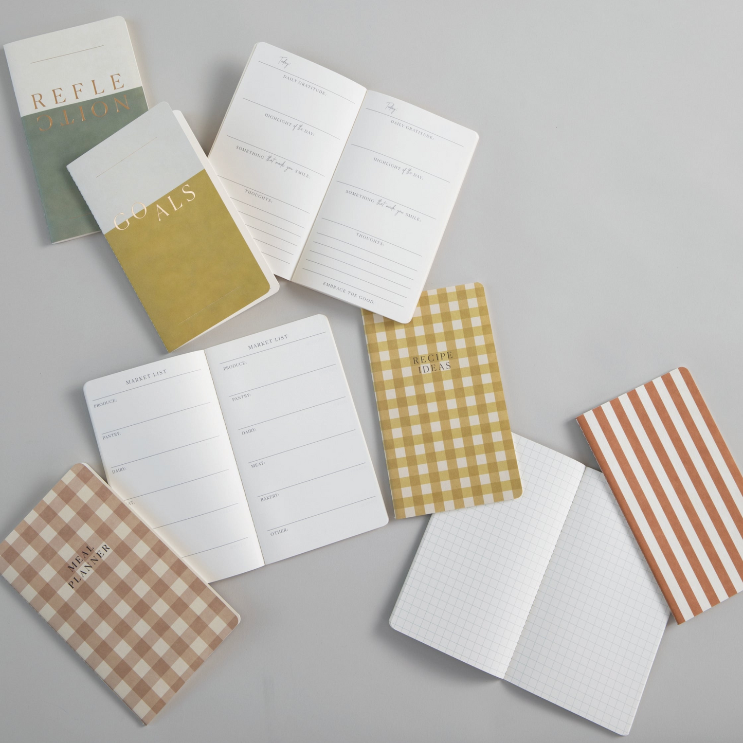 Planners lay on table, some are open and some closed.