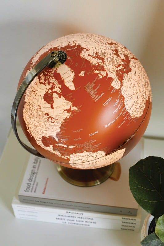 Orange and cream globe on a pile of books.